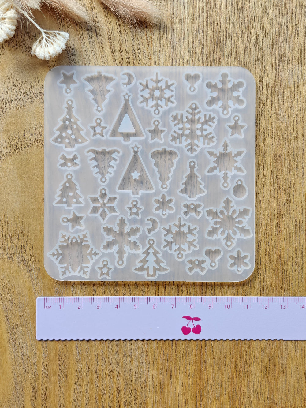 Jouluinen ja talvinen silikonimuotti, jossa useita erilaisia joulukuusia ja lumihiutaleita. Käyttö uv hartsin, eli koruhartsin tai kaksikomponenttisen epoksihartsin kanssa