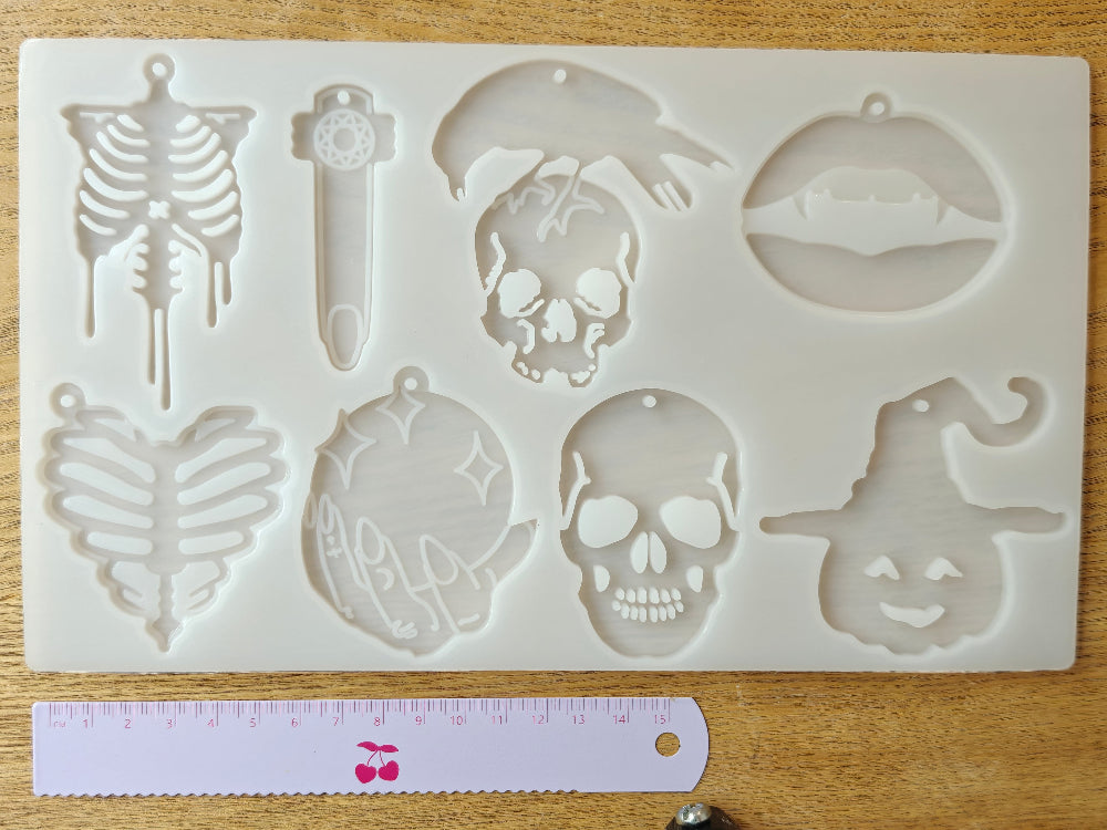 Erilaisia kalloja, luurankoja ja kurpitsanoidan sisältävä silikonimuotti, jotka sopivat hyvin myös halloween teemaan. Valmiina reikä korunosia varten. Käyttö uv hartsin, eli koruhartsin tai kaksikomponenttisen epoksihartsin kanssa