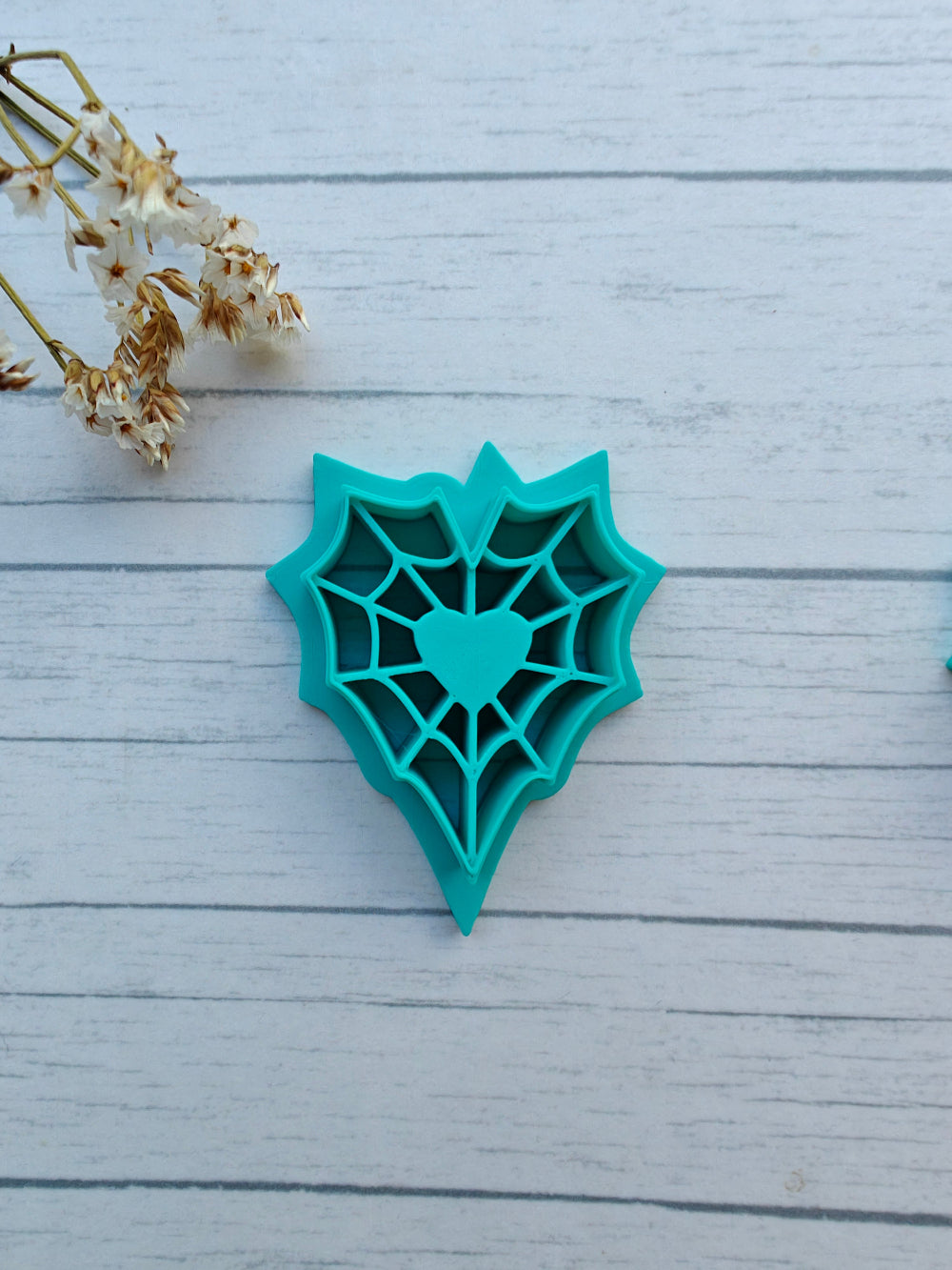 Sydämen muotoinen massamuotti hämähäkin verkko/seitti teemalla. Käytetään esimerkiksi fimo tai cernit massojen kanssa korujen tms. luomiseksi