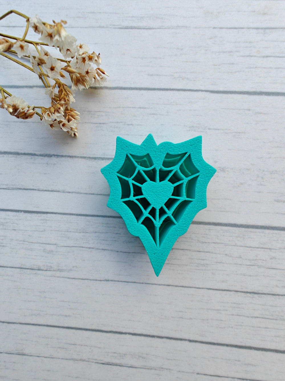 Sydämen muotoinen massamuotti hämähäkin verkko/seitti teemalla. Käytetään esimerkiksi fimo tai cernit massojen kanssa korujen tms. luomiseksi