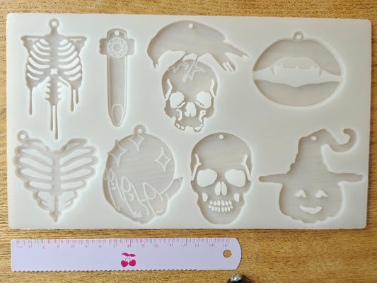 Erilaisia kalloja, luurankoja  ja kurpitsanoidan sisältävä silikonimuotti, jotka sopivat hyvin myös halloween teemaan. Valmiina reikä korunosia varten. Käyttö uv hartsin, eli koruhartsin tai kaksikomponenttisen epoksihartsin kanssa